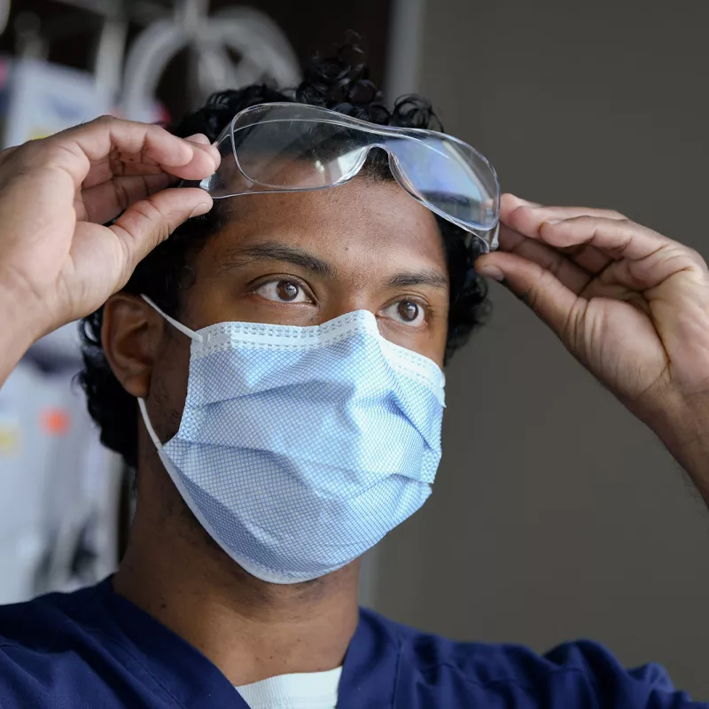 A nurse about to put on his work glasses